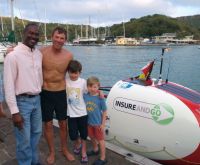 Charlie Pitcher with his sons greeted by Gerry Daniel of Antigua Tourism on arrival in English Harbour