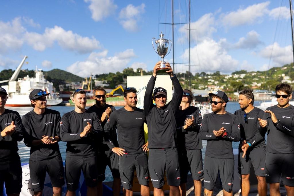 Skipper Grzegorz Baranowski proudly lifts the International Maxi Association Transatlantic Trophy for Monohull Line Honours © Arthur Daniel/RORC